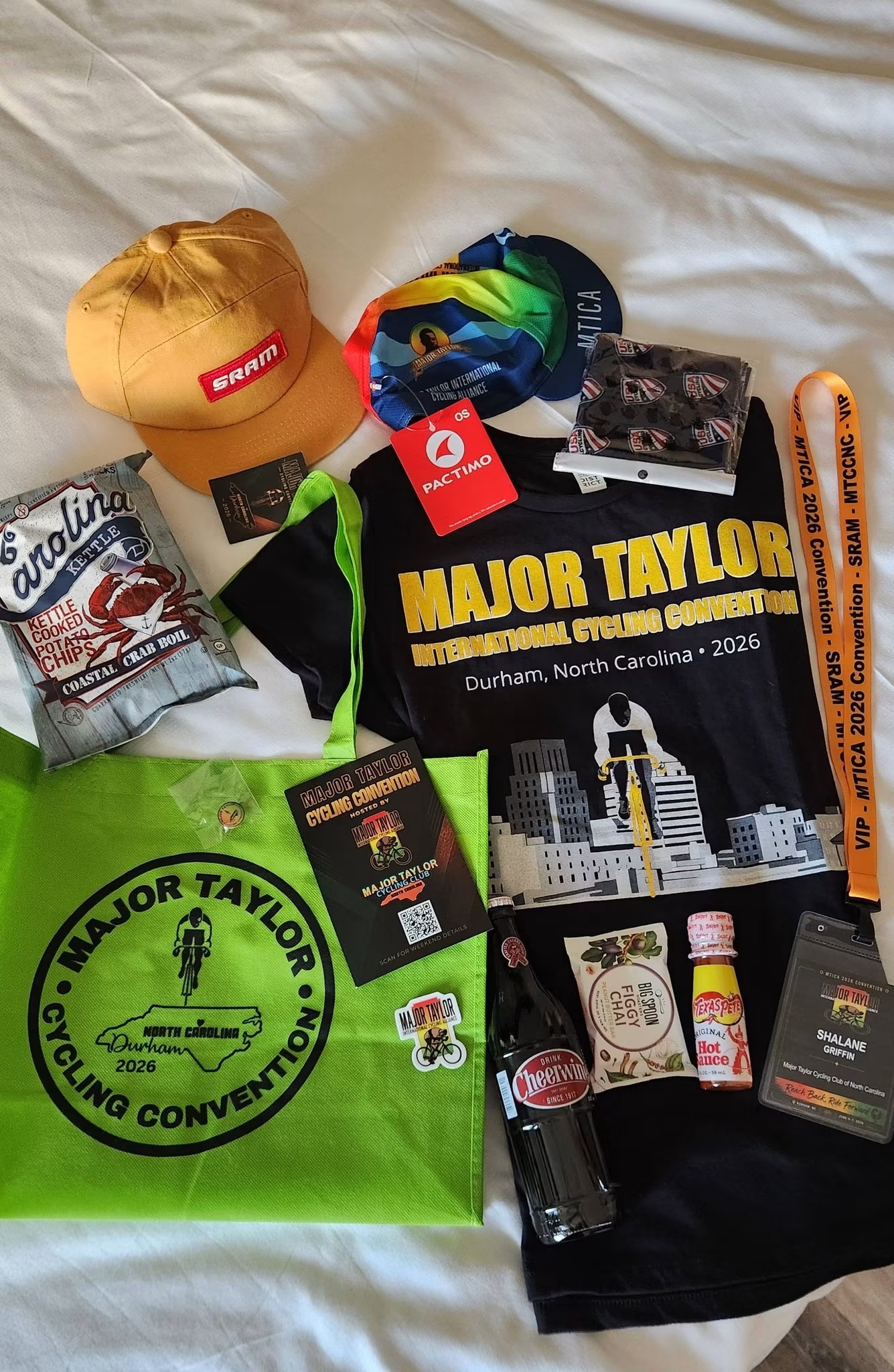 2026 MTICA Convention VIP swag bag contents including official jersey, SRAM hat, cycling accessories, Cheerwine, and Durham-themed items