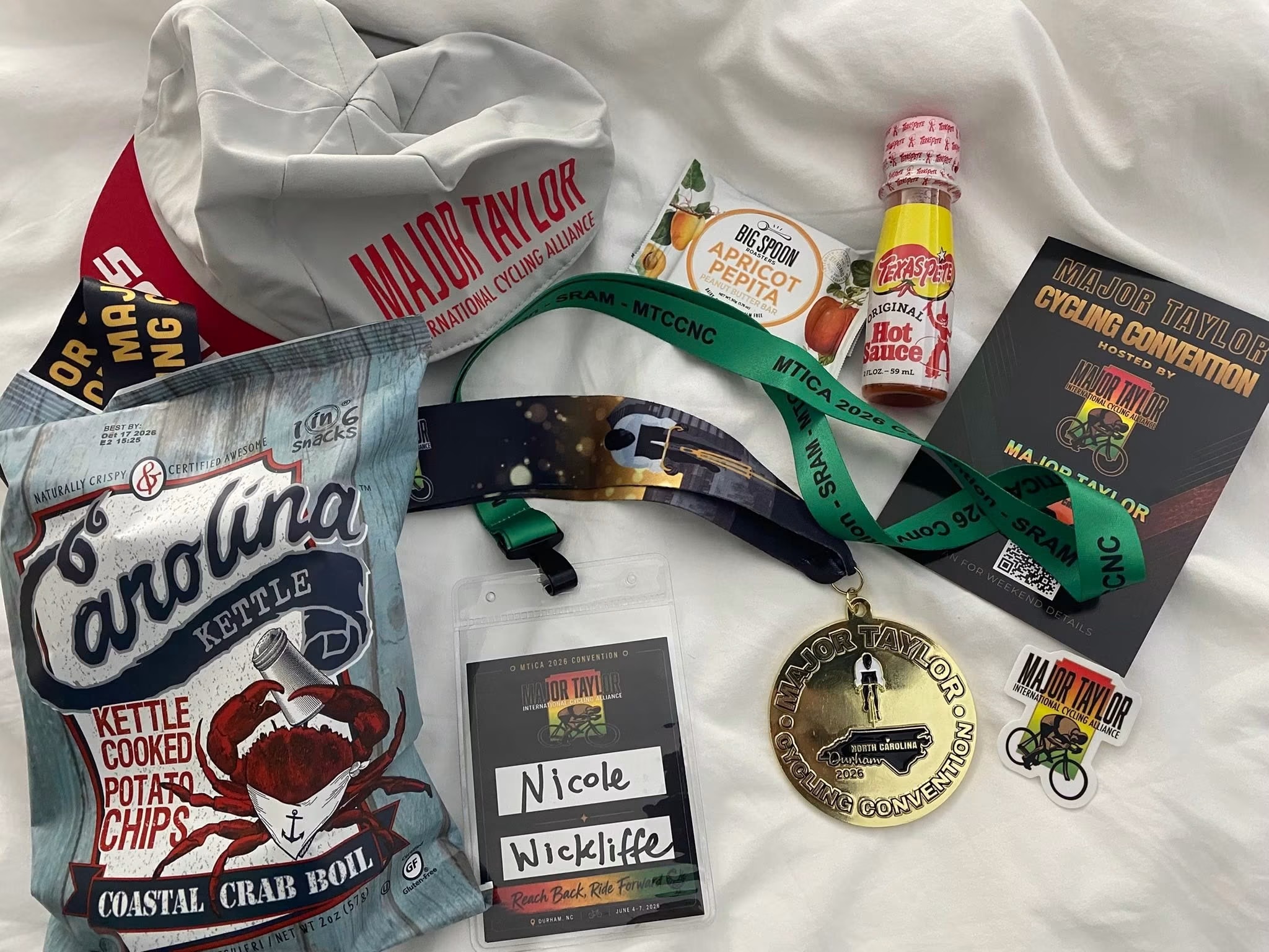 2026 MTICA Convention swag bag contents including finisher medal, lanyard, sticker, and Durham snacks