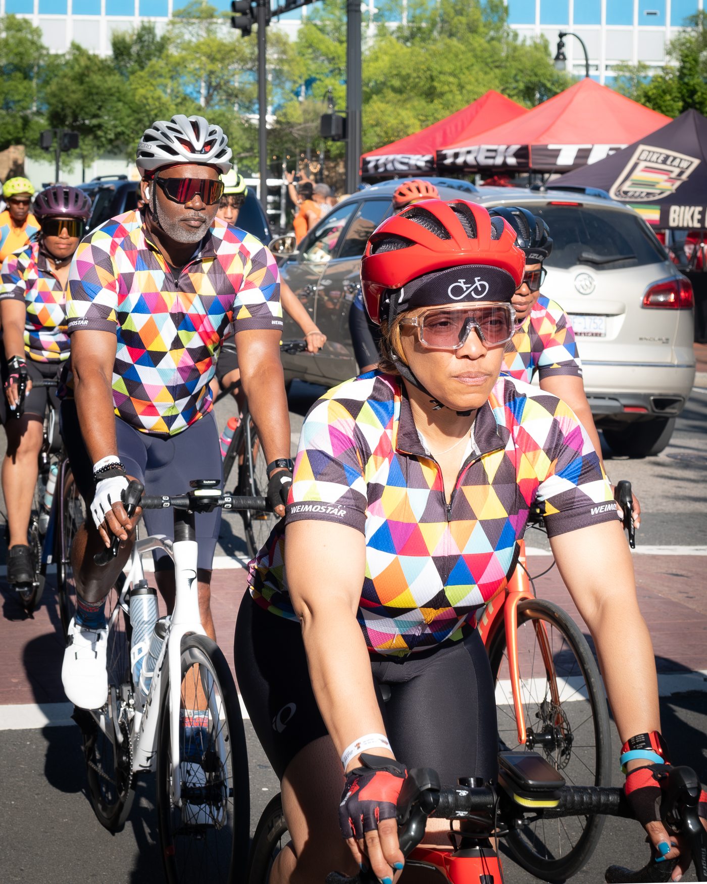 Cyclists in colorful jerseys riding out from the wave start during the MTICA 2026 Convention Saturday ride in downtown Durham NC