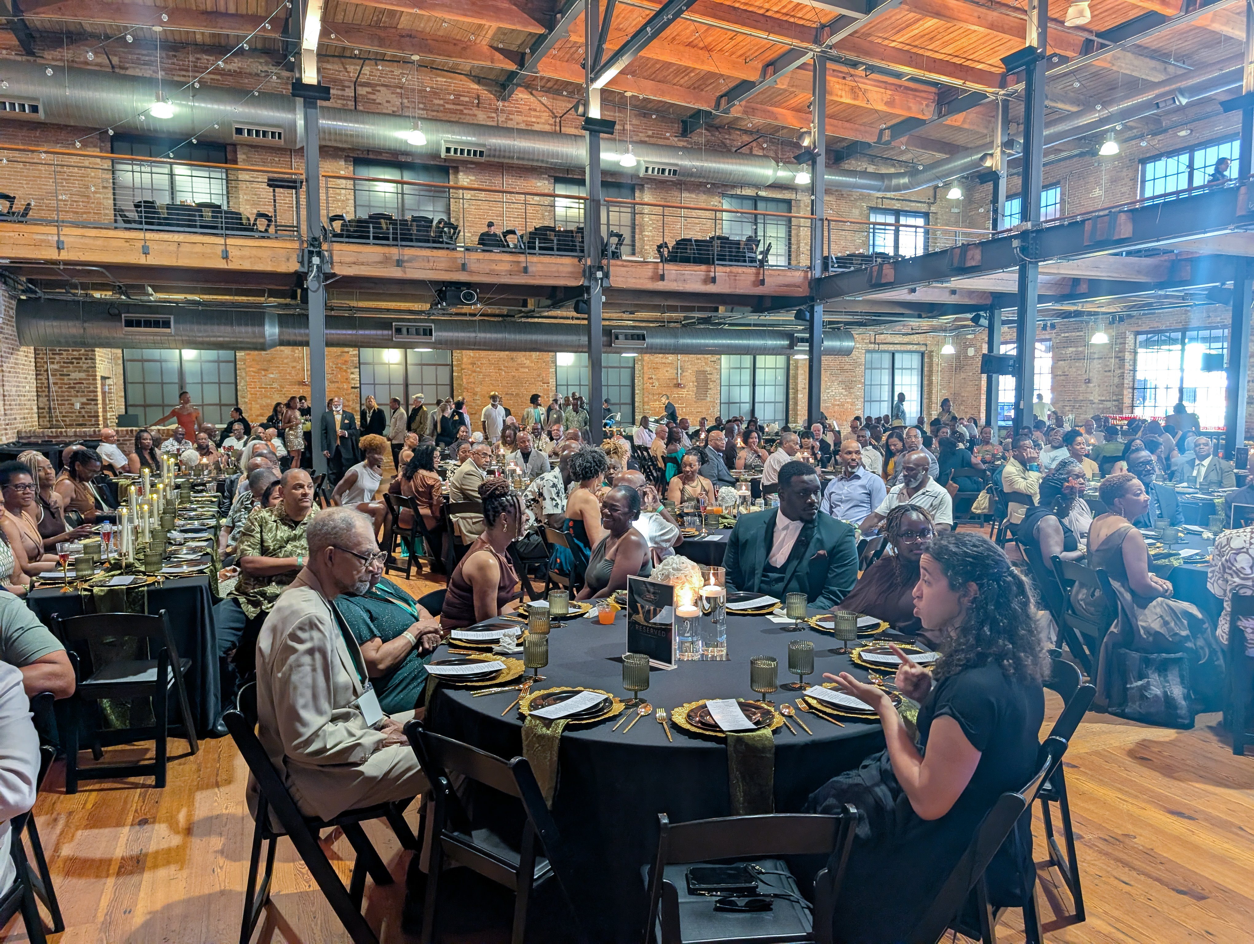 Interior of Bay 7 during the MTICA 2026 Major Taylor Legacy Dinner showing candlelit tables and hundreds of guests in the American Tobacco District Durham NC