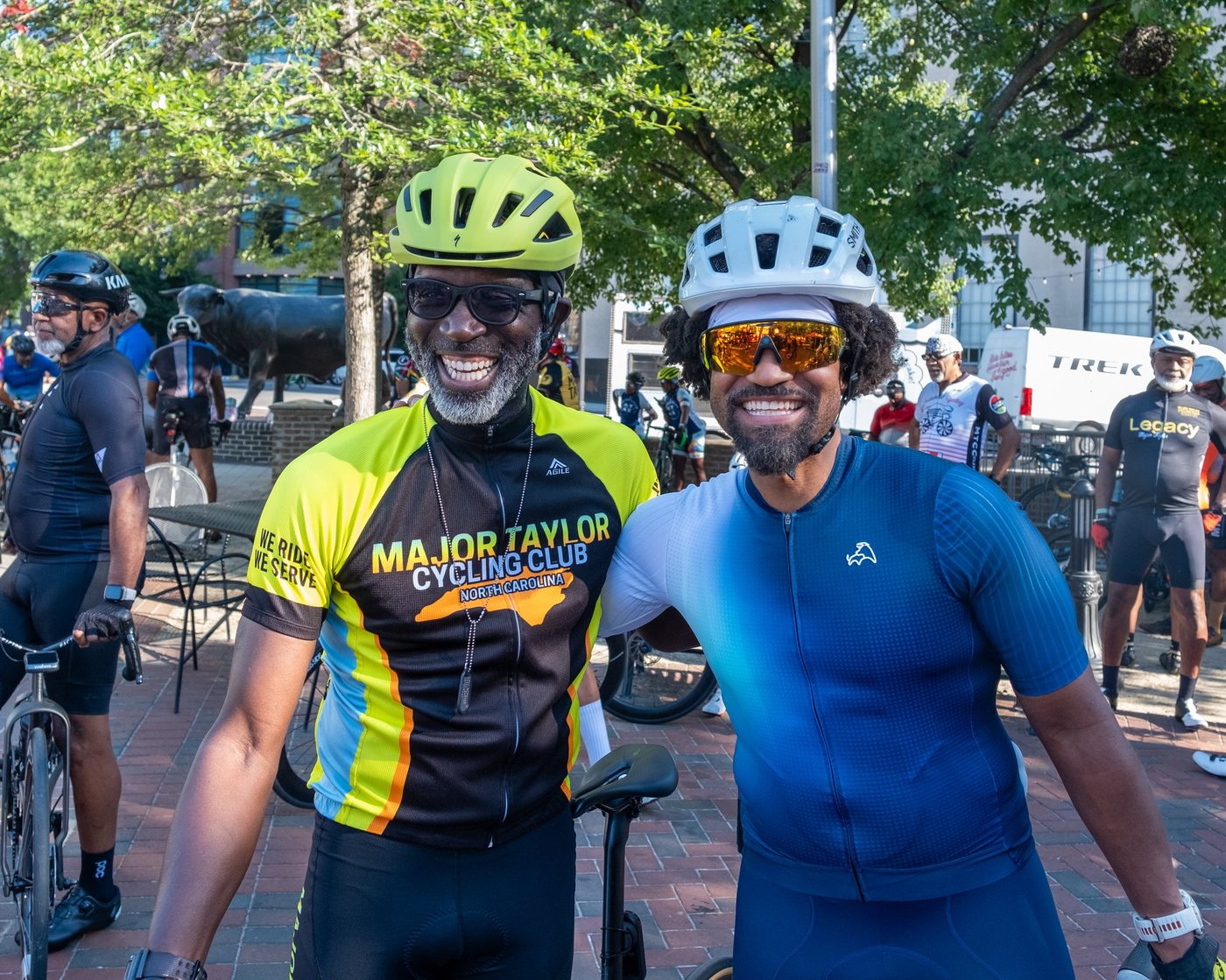 Two cyclists smiling together at the CCB Plaza start line during the MTICA 2026 Major Taylor Cycling Convention in Durham NC