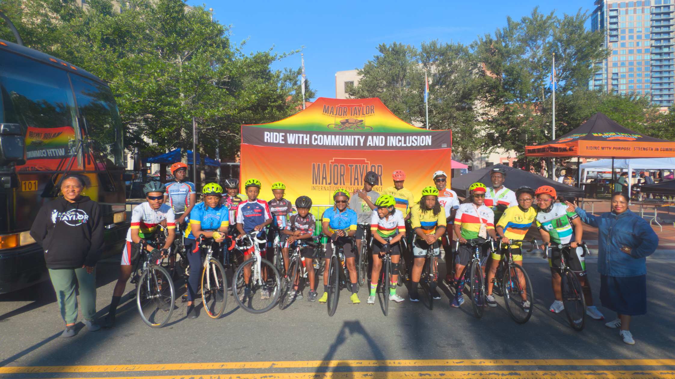 Youth cyclists with helmets and bikes lined up at the MTICA 2026 Convention start in downtown Durham NC with the Major Taylor International Cycling Alliance banner