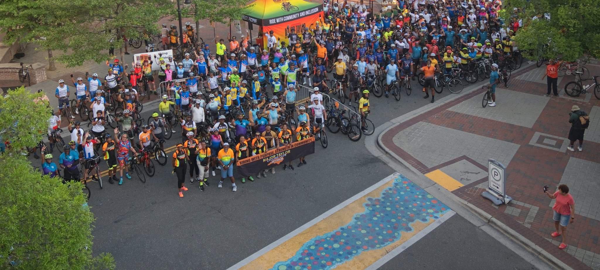 Riders at the 2026 Major Taylor national convention in Durham holding a banner reading Riding with purpose, strength in community